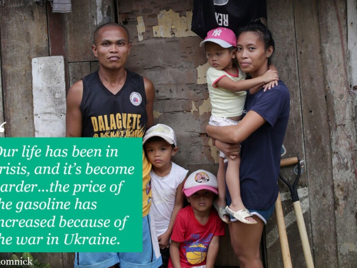 Family group together outside wooden home in philippines