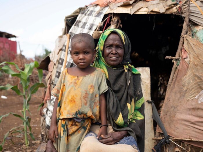 Woman and child outside a shelter covered in fabric