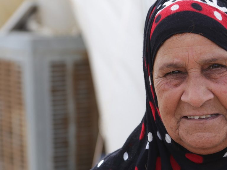 Woman in headscarf outside a tent in Iraq