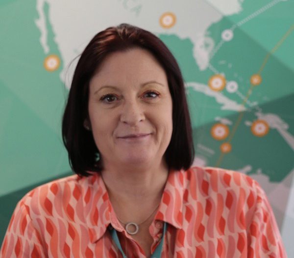 Woman wearing a patterned shirt sitting in front of a map